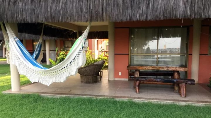 Covered ground-floor terrace with hammock and garden at Dream Village 401-H
